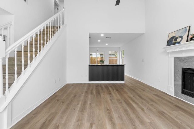 1725 Colonial Ct, Fort Walton Beach, FL 32547 - unfurnished living room featuring a towering ceiling, stairs, wood finished floors, a fireplace, and baseboards
