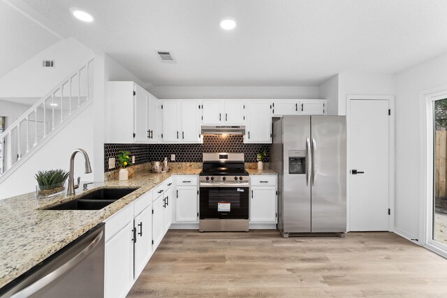 1725 Colonial Ct, Fort Walton Beach, FL 32547 - kitchen with stainless steel appliances, a sink, light stone counters, under cabinet range hood, and white cabinetry