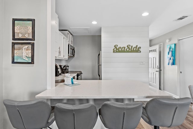 775 Gulf Shore Dr Unit 8250, Destin, FL 32541 - kitchen featuring appliances with stainless steel finishes, a peninsula, white cabinets, light stone counters, and recessed lighting