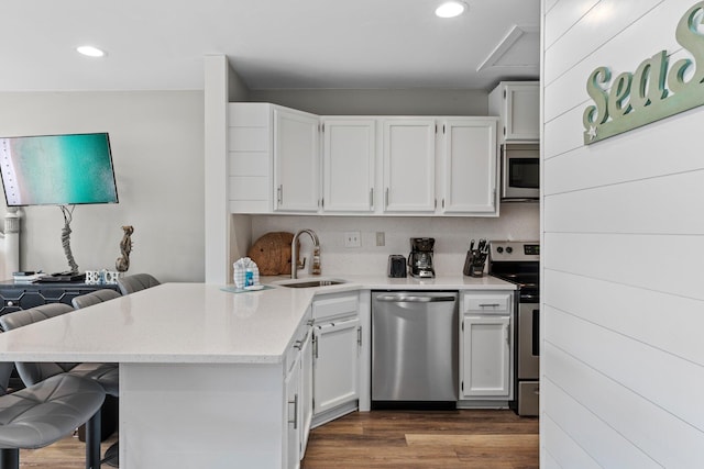 775 Gulf Shore Dr Unit 8250, Destin, FL 32541 - kitchen featuring stainless steel appliances, a sink, a breakfast bar area, a peninsula, and white cabinetry