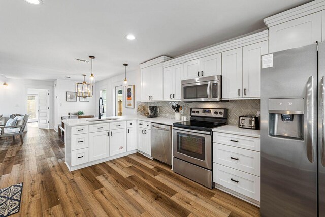 65 Brown St, Santa Rosa Beach, FL 32459 - kitchen featuring stainless steel appliances, a sink, a peninsula, light countertops, and open floor plan