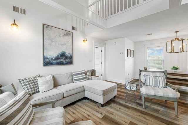 65 Brown St, Santa Rosa Beach, FL 32459 - living area with a chandelier, wood finished floors, baseboards, and a towering ceiling