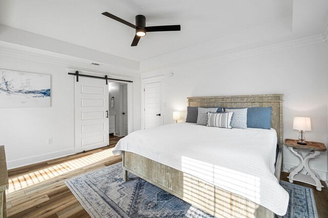 65 Brown St, Santa Rosa Beach, FL 32459 - bedroom with a barn door, wood finished floors, baseboards, ceiling fan, and ornamental molding