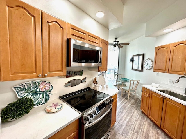 1096 Scenic Gulf Dr Ph 1610, Miramar Beach, FL 32550 - kitchen with appliances with stainless steel finishes, a sink, a ceiling fan, light countertops, and light wood-style flooring