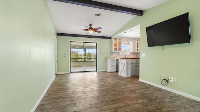 unfurnished living room with dark wood finished floors, ceiling fan, baseboards, and a sink