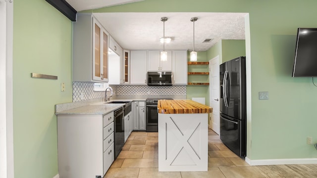 kitchen with black appliances, butcher block counters, backsplash, open shelves, and baseboards