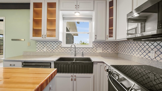 kitchen featuring stainless steel appliances, a sink, decorative backsplash, glass insert cabinets, and white cabinetry