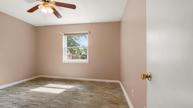 spare room featuring baseboards, a ceiling fan, and wood finished floors
