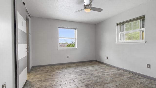unfurnished room featuring ceiling fan, wood finished floors, and baseboards