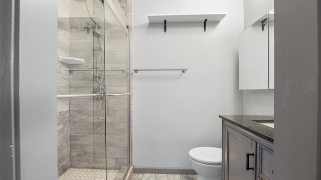 full bath with a stall shower, vanity, and toilet