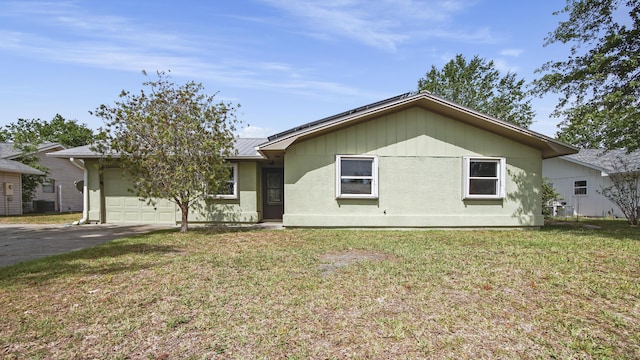 ranch-style home with a garage, driveway, a front lawn, metal roof, and central AC