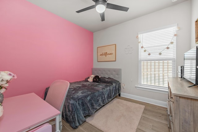 bedroom featuring baseboards, wood finished floors, and ceiling fan