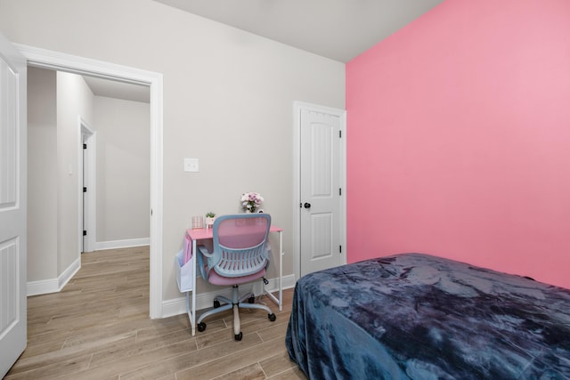 bedroom with wood finished floors and baseboards