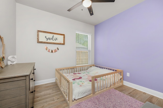 bedroom with light wood-type flooring, baseboards, and ceiling fan