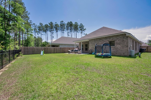 view of yard featuring outdoor lounge area, a trampoline, and a patio