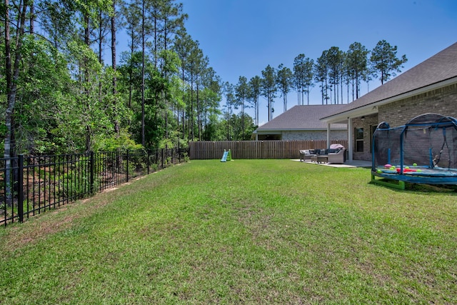 view of yard featuring a trampoline and an outdoor living space