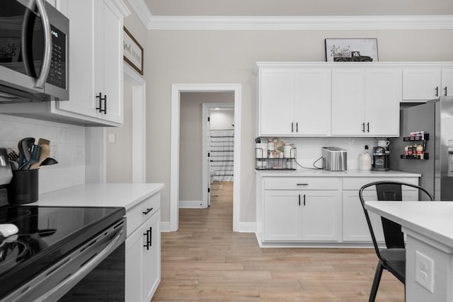 kitchen featuring stainless steel appliances, light countertops, crown molding, decorative backsplash, and white cabinetry