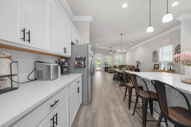 kitchen featuring plenty of natural light, recessed lighting, ornamental molding, white cabinets, and light countertops