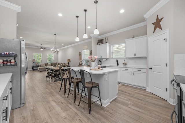 kitchen featuring stainless steel appliances, open floor plan, a sink, a breakfast bar area, and backsplash