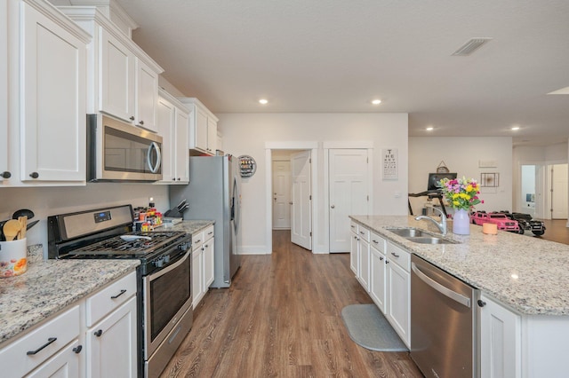 1126 Valor Walk, Crestview, FL 32539 - kitchen with stainless steel appliances, a sink, white cabinets, dark wood finished floors, and recessed lighting