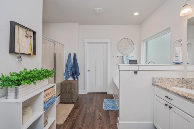 1126 Valor Walk, Crestview, FL 32539 - bathroom featuring wood finished floors, a shower stall, a garden tub, vanity, and baseboards