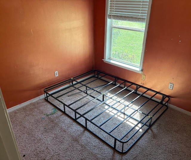 carpeted spare room featuring baseboards