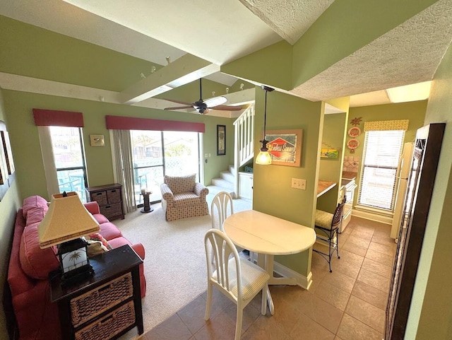 dining area featuring stairs, a ceiling fan, light tile patterned floors, a textured ceiling, and baseboards