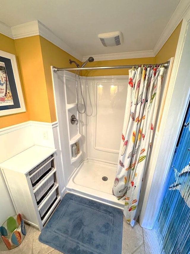 bathroom featuring curtained shower, ornamental molding, and a wainscoted wall