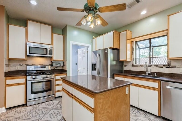 84 12th St, Shalimar, FL 32579 - kitchen featuring appliances with stainless steel finishes, a sink, backsplash, ceiling fan, and recessed lighting