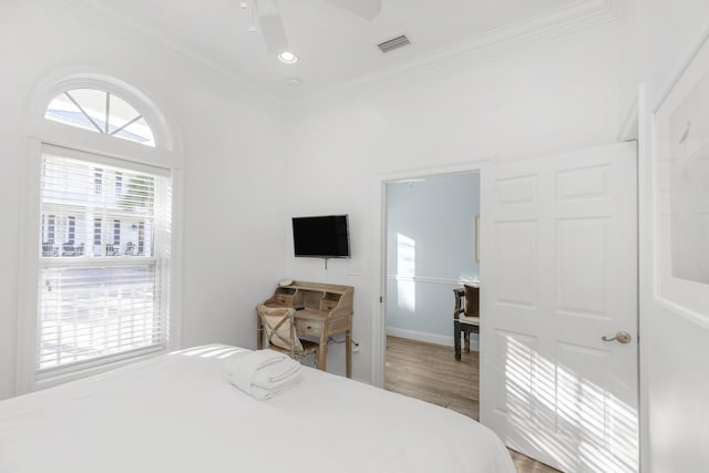 bedroom featuring ornamental molding, wood finished floors, ceiling fan, and baseboards