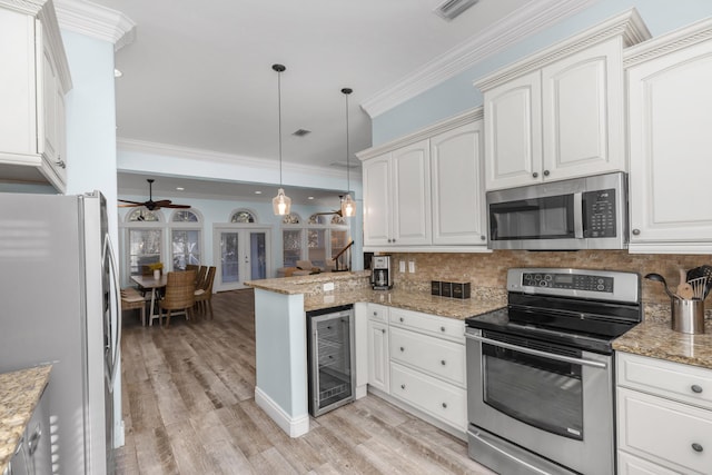 kitchen with stainless steel appliances, wine cooler, a ceiling fan, backsplash, and ornamental molding