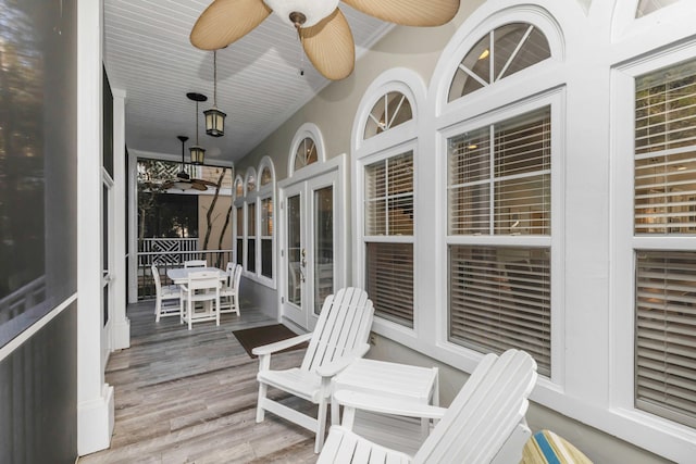 sunroom / solarium featuring french doors, ceiling fan, and wood finished floors