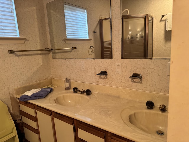 bathroom featuring plenty of natural light, double vanity, and an enclosed shower