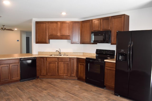 575 Earl Godwin Rd, Freeport, FL 32439 - kitchen with black appliances, a sink, recessed lighting, dark wood-type flooring, and brown cabinets