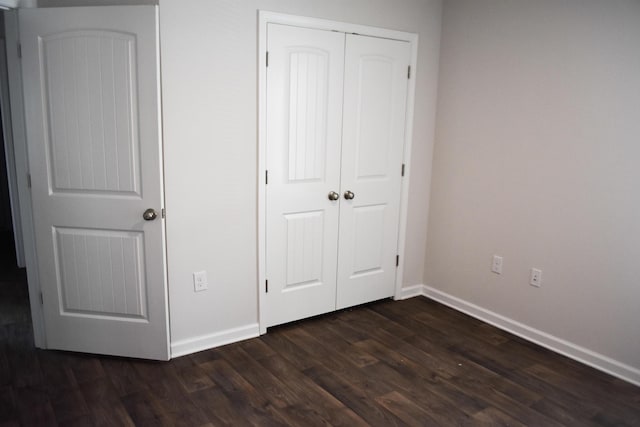 575 Earl Godwin Rd, Freeport, FL 32439 - unfurnished bedroom with baseboards, a closet, and dark wood-style floors