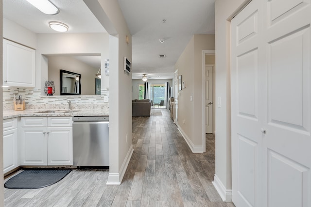 4274 Calinda Ln Unit 215, Niceville, FL 32578 - kitchen with dishwasher, a sink, light wood-type flooring, and white cabinets