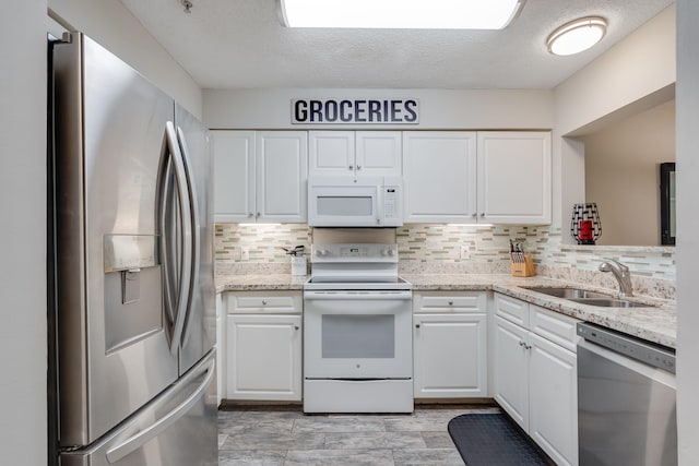 4274 Calinda Ln Unit 215, Niceville, FL 32578 - kitchen with appliances with stainless steel finishes, a sink, white cabinets, and a textured ceiling