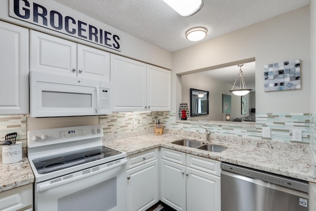 4274 Calinda Ln Unit 215, Niceville, FL 32578 - kitchen with white appliances, a sink, white cabinetry, decorative backsplash, and a textured ceiling