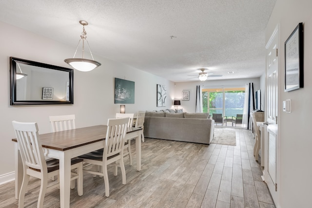 4274 Calinda Ln Unit 215, Niceville, FL 32578 - dining space with a textured ceiling, a ceiling fan, and light wood-type flooring