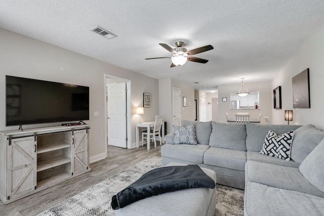 4274 Calinda Ln Unit 215, Niceville, FL 32578 - living room with ceiling fan, light wood-style floors, a textured ceiling, and baseboards