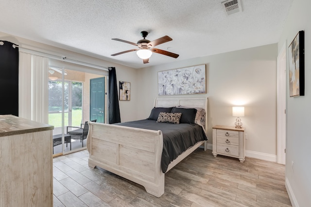 4274 Calinda Ln Unit 215, Niceville, FL 32578 - bedroom featuring access to outside, light wood-style floors, a textured ceiling, baseboards, and a ceiling fan
