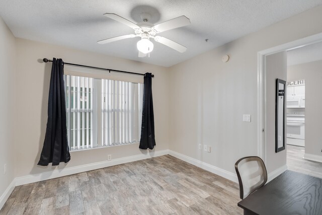 4274 Calinda Ln Unit 215, Niceville, FL 32578 - unfurnished office featuring light wood-style floors, a ceiling fan, baseboards, and a textured ceiling