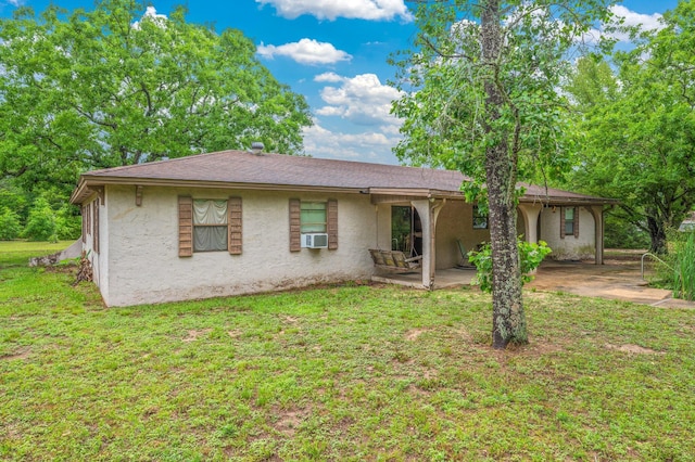 view of front of house with stucco siding, a patio, a front yard, and cooling unit