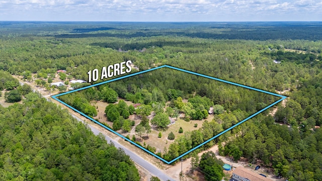 aerial overview of property's location with a heavily wooded area and property parcel outlined
