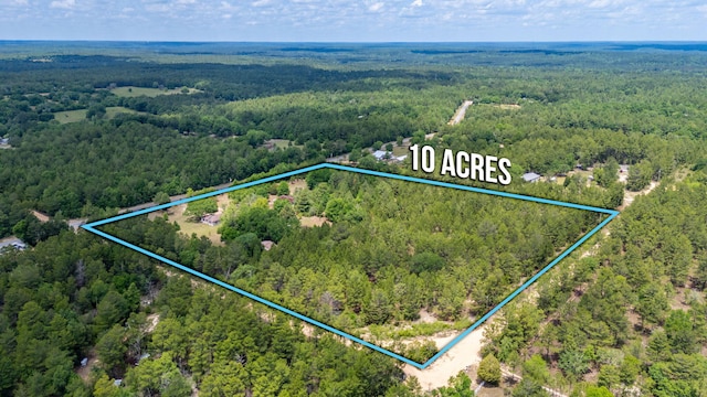 aerial view of property and surrounding area featuring a forest and property parcel outlined