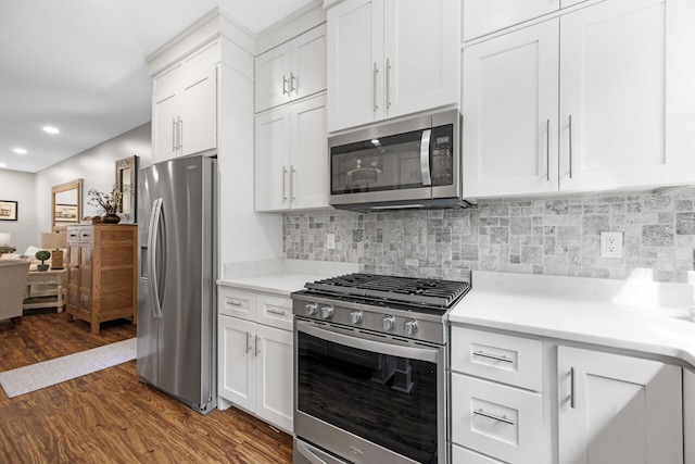 1650 Caswell Rd, Defuniak Springs, FL 32433 - kitchen with stainless steel appliances, dark wood-style flooring, white cabinetry, light countertops, and backsplash