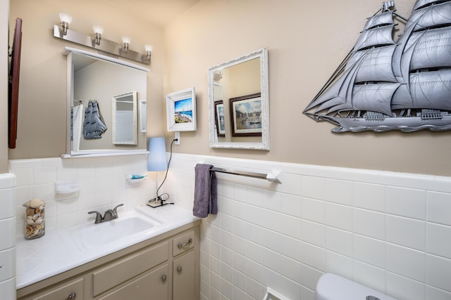 327 NE Yacht Club Dr, Fort Walton Beach, FL 32548 - bathroom with wainscoting, tile walls, vanity, and toilet
