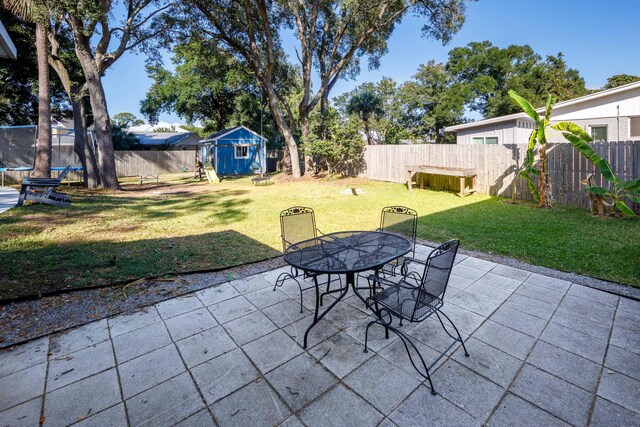327 NE Yacht Club Dr, Fort Walton Beach, FL 32548 - view of patio featuring a trampoline, a shed, an outbuilding, and outdoor dining space