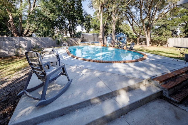 327 NE Yacht Club Dr, Fort Walton Beach, FL 32548 - view of pool featuring a trampoline, an outdoor structure, a fenced backyard, and a patio