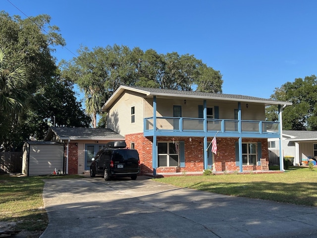 327 NE Yacht Club Dr, Fort Walton Beach, FL 32548 - view of front of home with a balcony, driveway, brick siding, and a front lawn